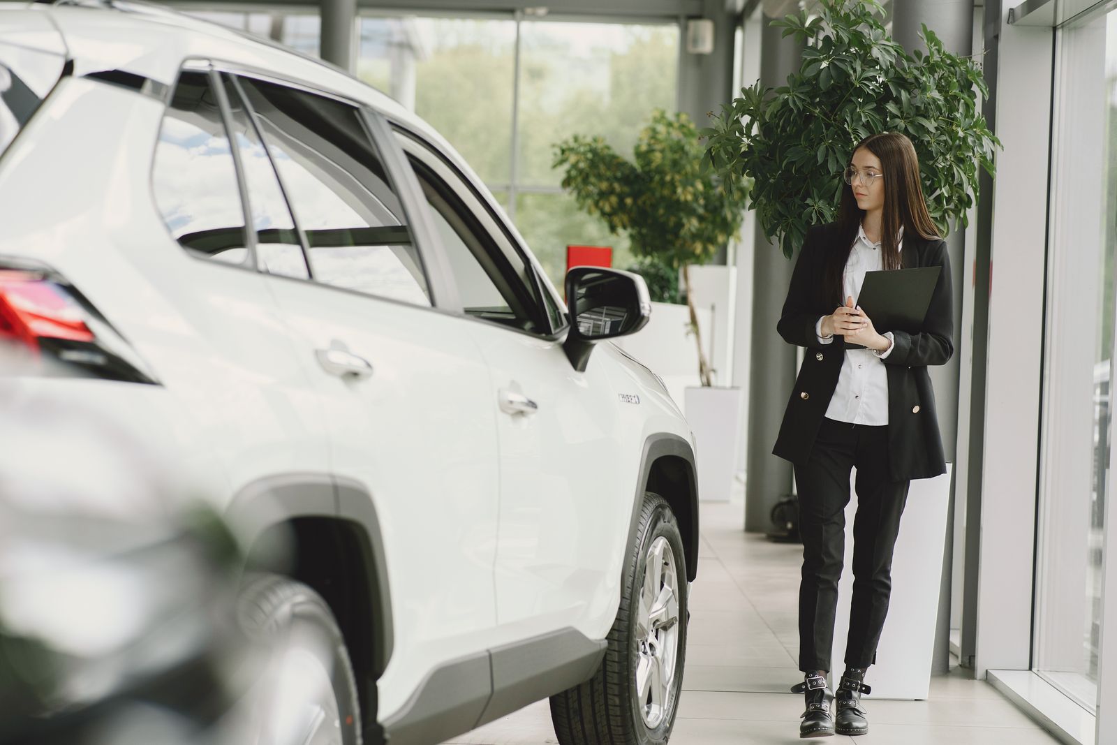 Car buyer inspecting a vehicle at a dealership before purchase