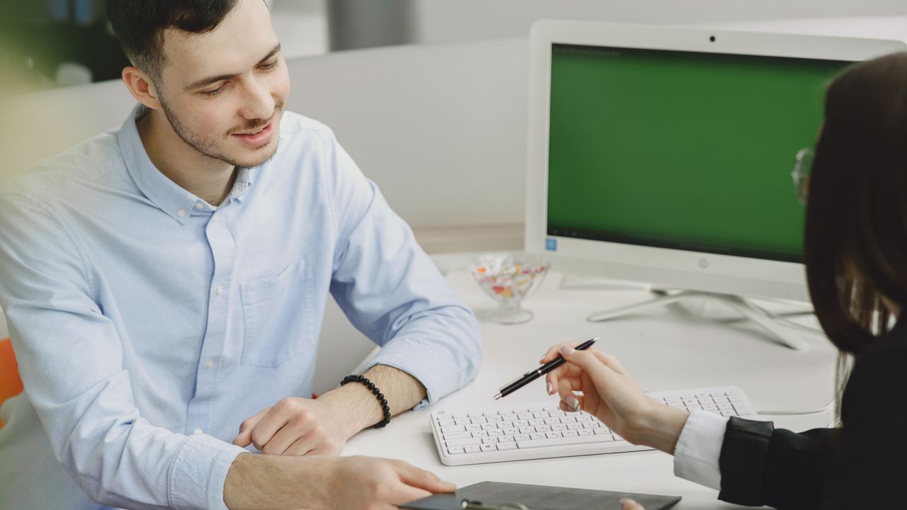 Colleagues discussing project details at a modern office desk