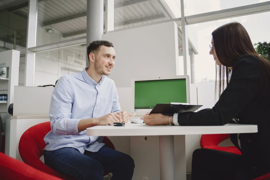Um homem e uma mulher envolvidos em uma reunião profissional em uma mesa de escritório moderna.
