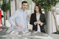 Man in White Dress Shirt Standing Beside Woman in Black Blazer