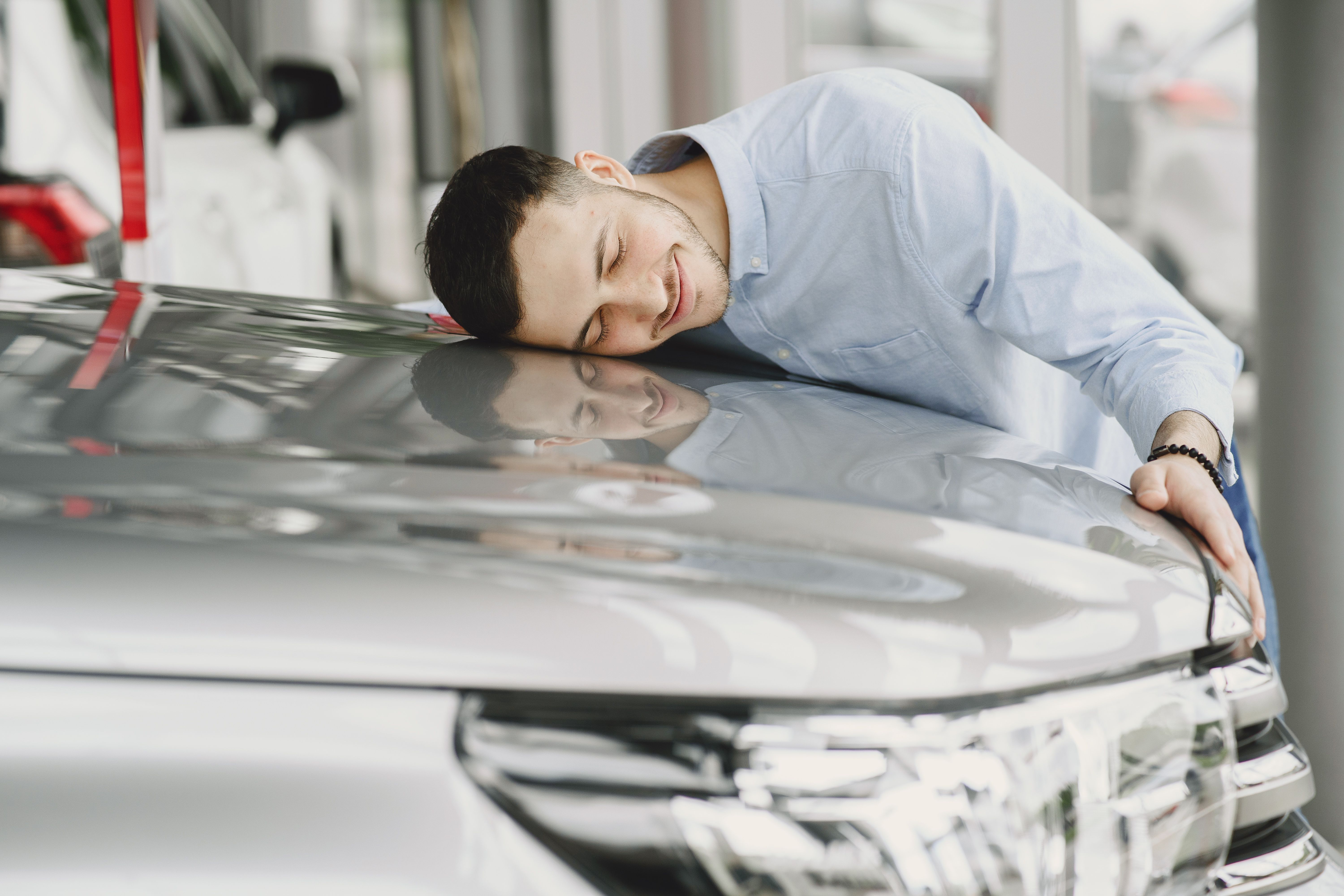 Man Smiling and Hugging His Car