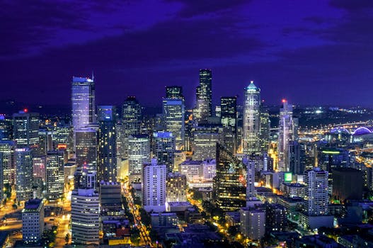 A vibrant aerial view of Seattle's illuminated skyline at night featuring iconic skyscrapers.
