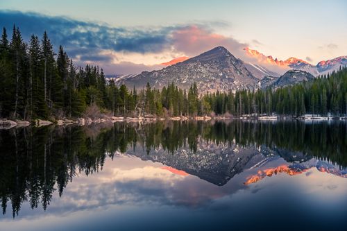 Free Serene sunrise over Rocky Mountains reflecting in a tranquil lake. Stock Photo