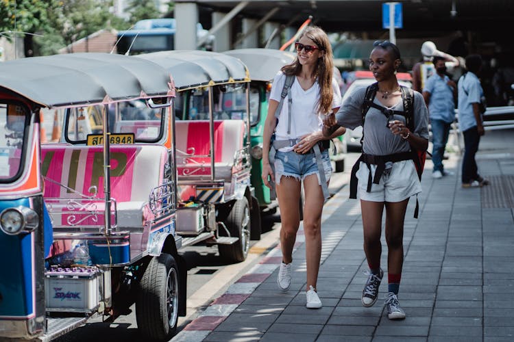 Women Looking At Tourist Bus In City