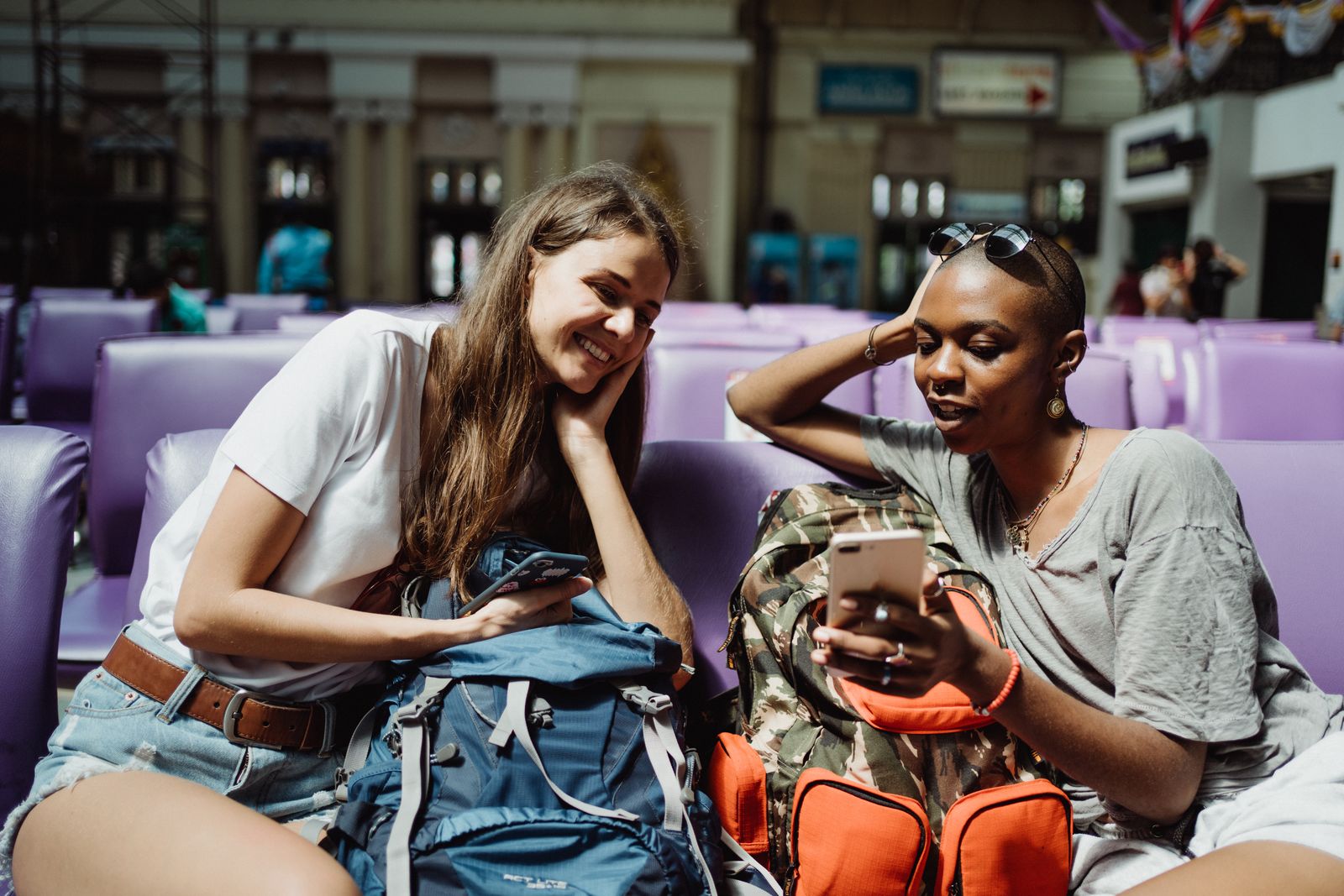 International travelers using smartphones in an airport lounge