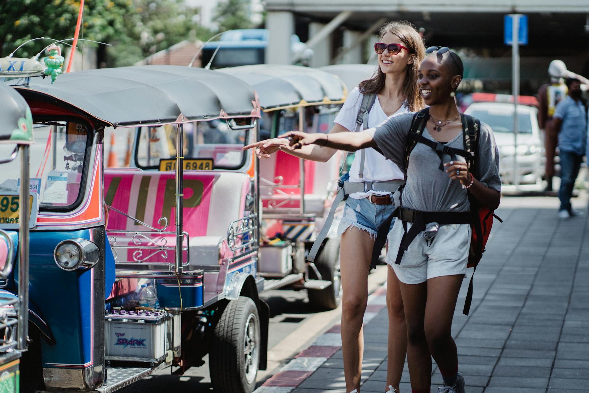 Two women exploring the city by tuk-tuk, enjoying a day of travel and adventure.