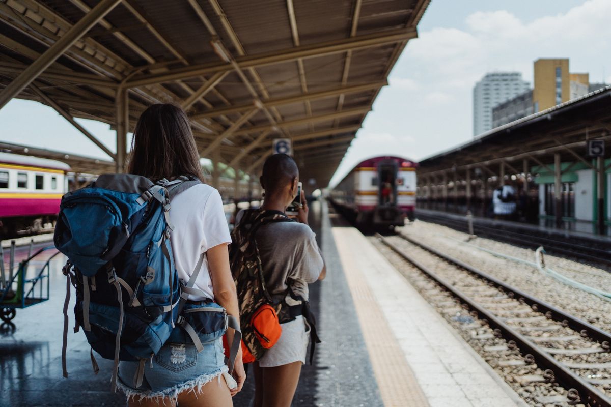 Backpackers with travel backpacks at a railway station ready for a journey