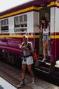 Woman in Black and Red Long Sleeve Shirt Standing Beside Train