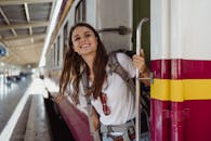 Woman in White Long Sleeve Shirt Standing Beside White Metal Railings