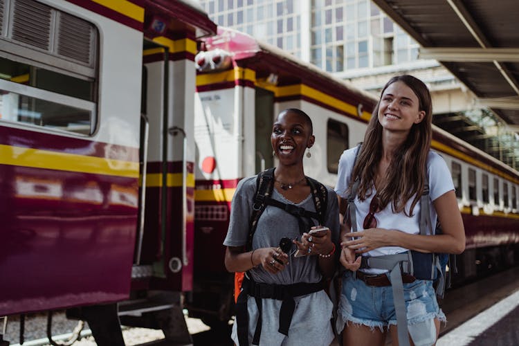 Laughing Backpackers On Railway Station Platform