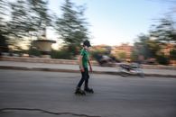 Man in Green Jacket and Black Pants Walking on Street