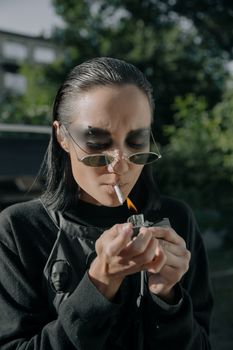 一位女士在户外点燃一支香烟，她留着光滑的头发，体现了赛博朋克风格