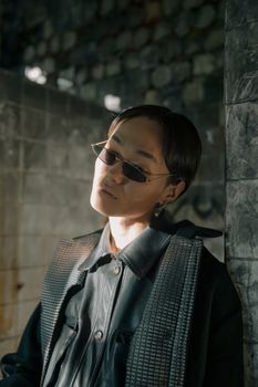 这是一张引人注目的肖像照，一位身着未来派服装、戴着太阳镜的模特在城市环境中拍摄而成