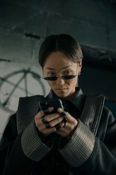 一位时尚模特穿着赛博朋克服装在室内接触科技