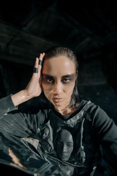 一名女子化着深色网络朋克妆容，身着未来派服装，正戏剧性地摆出姿势