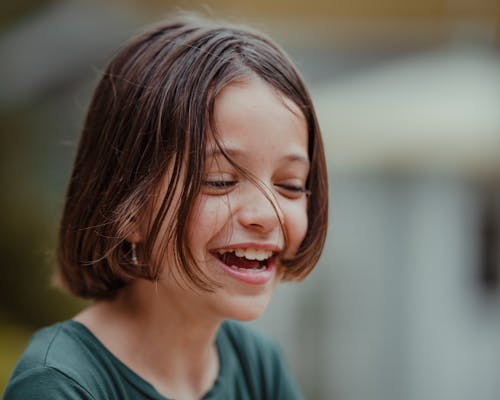 Cute girl with short hair laughing cheerfully