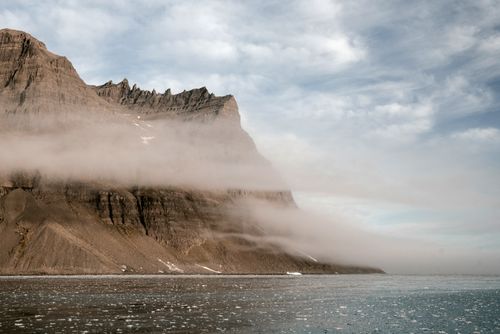 Coastal cliff meeting the sea in fog, photo by ArtHouse Studio on Pexels