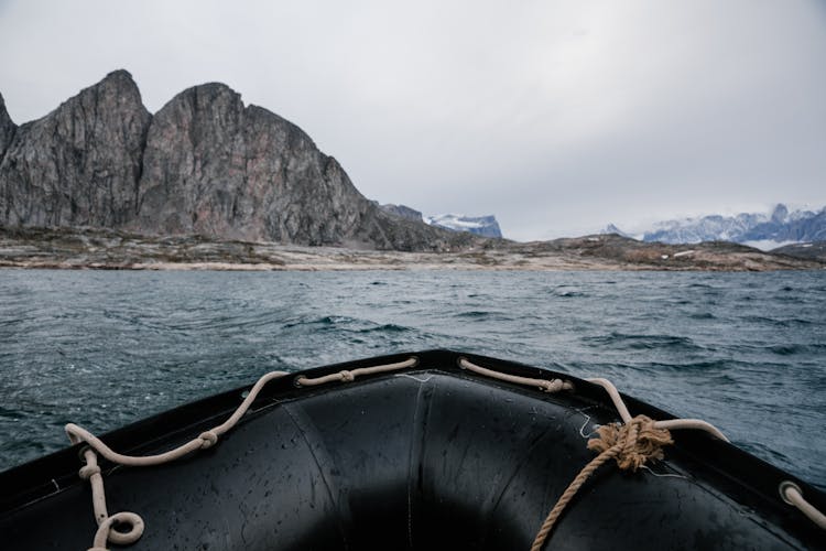 Black Boat On Sea Near Mountain