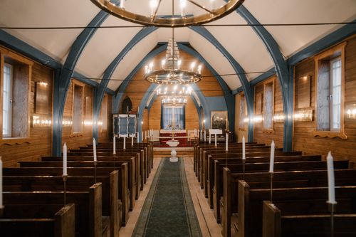 Free Elegant interior of a wooden church featuring chandeliers and pews, exuding a classic ambiance. Stock Photo