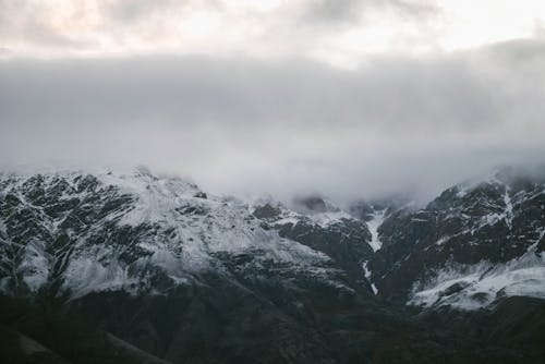 Snow Covered Mountain in Clouds