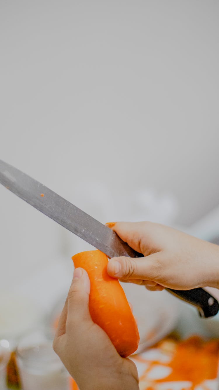 Crop Cook Cutting Carrot In Kitchen