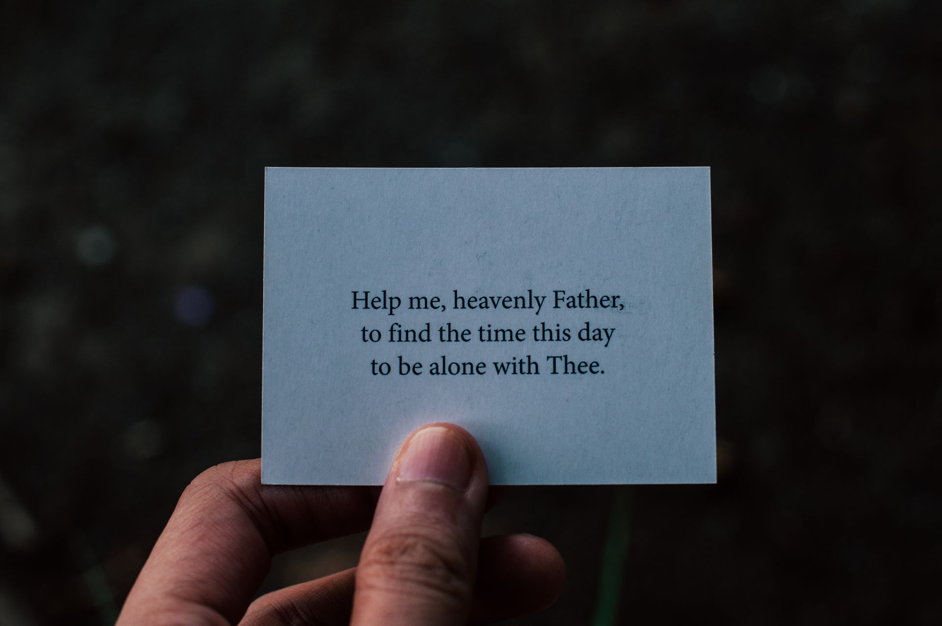 Close-up of a hand holding a card with a prayer for guidance.
