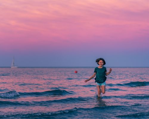 Free Happy girl in casual clothes playing in water while having free time during summer vacation Stock Photo