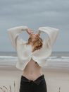 Unrecognizable sensual woman with naked belly on sea beach