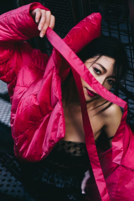 From above of young ethnic female with makeup in colorful clothes with belt looking at camera in evening
