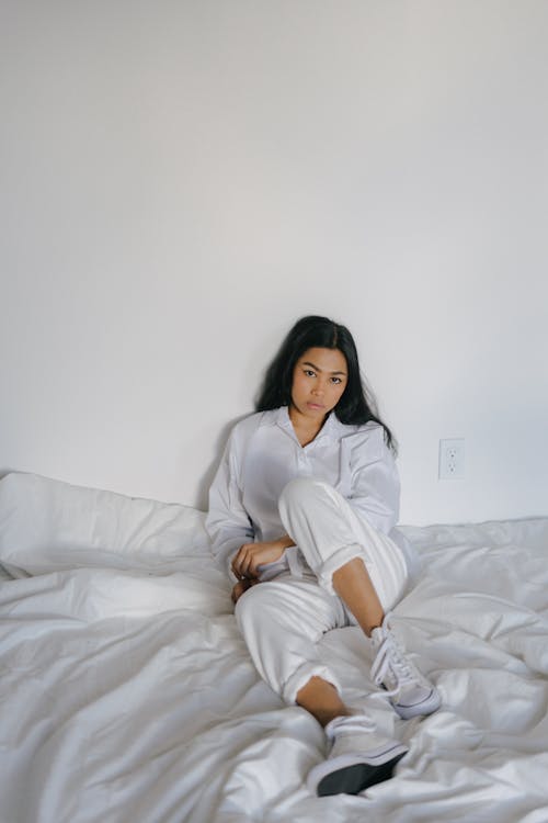 침대에 쉬고 흰색 착용에 아시아 여자