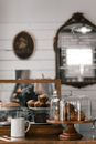 Assorted tasty muffins and puffs on stand near piece of chocolate cake in modern pastry shop