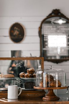 现代糕点店的架子上，巧克力蛋糕旁边摆放着各种美味的松饼和泡芙