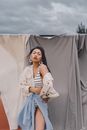 Stylish sensual ethnic woman near textiles on street