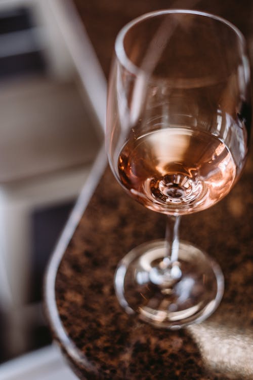 High angle of transparent glass of fine wine on marble table at home