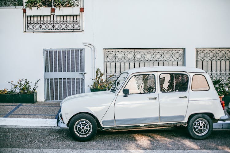 Retro Car Parked Near Asphalt Sidewalk In Front Of Building