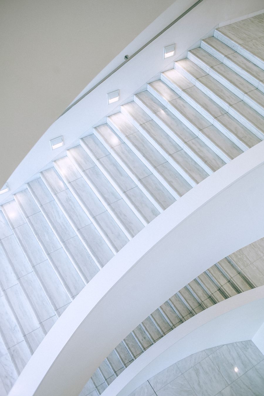 Illuminated modern white staircase in a renovated home