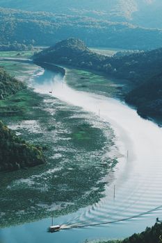 从上方俯瞰，一条风景如画的河流蜿蜒穿过郁郁葱葱的山丘，景色宁静