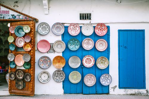 Free Exterior of vintage local store with colorful traditional ornamental goods on cement walls near wooden entrance Stock Photo