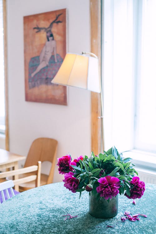 Vase with flowers on table in room
