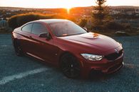 Contemporary shiny expensive automobile with headlights parked on asphalt in bright sunset of town