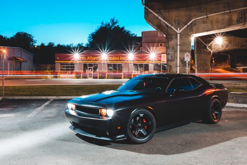 Free Modern car parked on concrete road with green lawn near stone tunnel in late evening Stock Photo