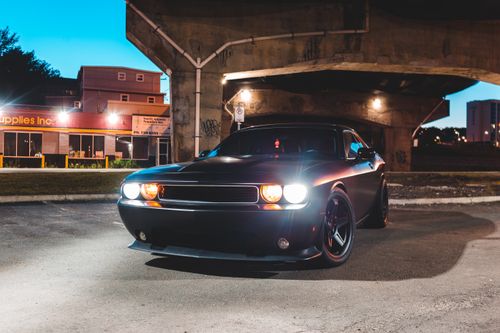Free Black brutal automobile standing on asphalt road near concrete construction in early morning Stock Photo