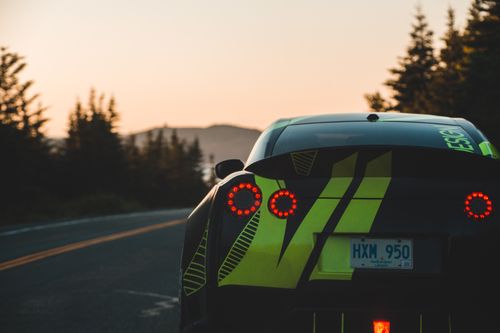 Free Bright modern automobile with luminous tail light on concrete road in picturesque countryside Stock Photo