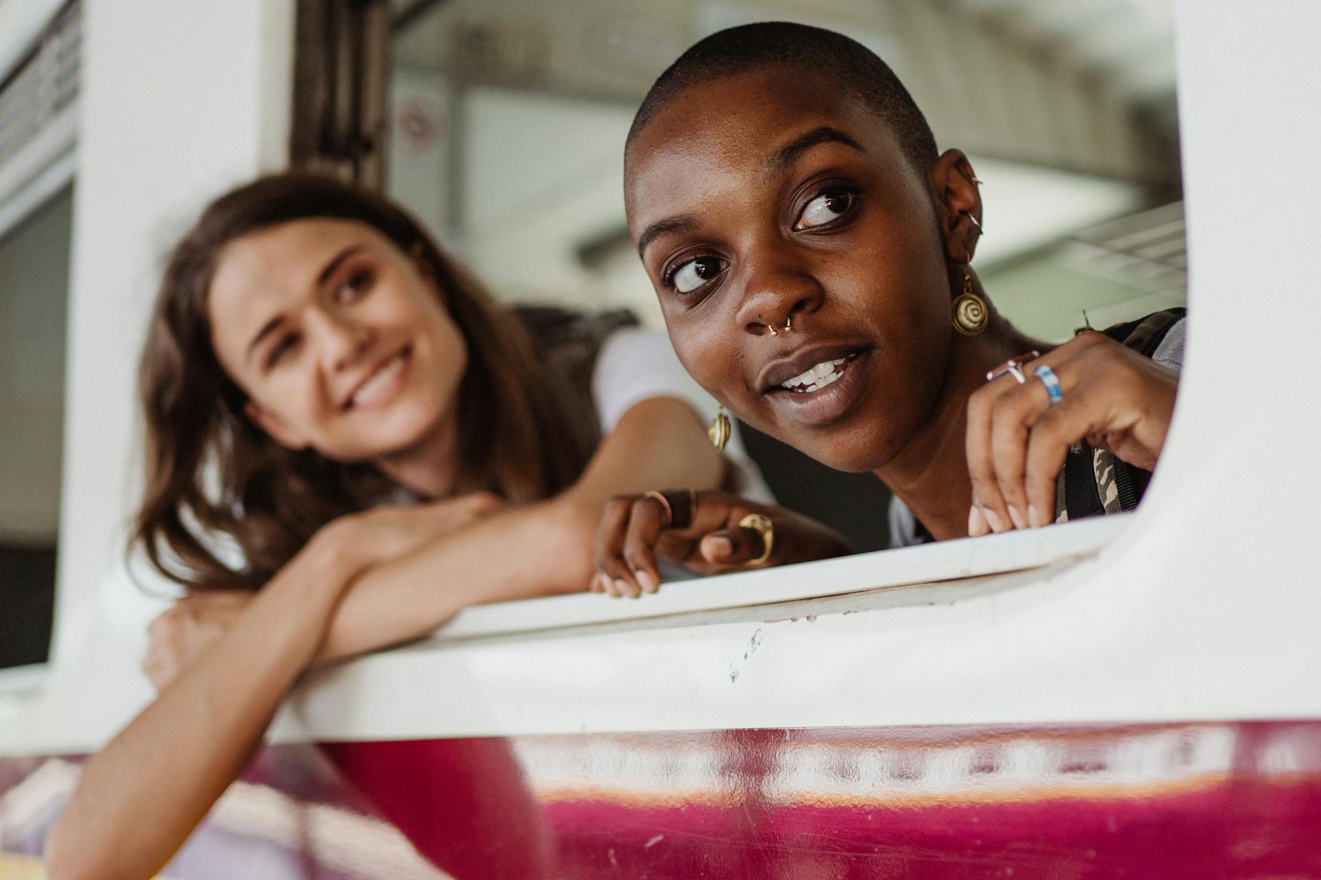 Two women looking out a train window, enjoying travel and adventure.