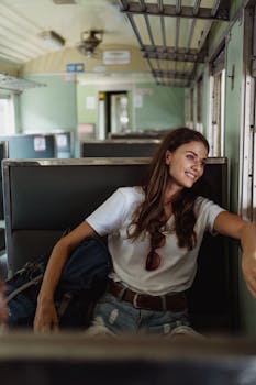 一位长发女子面带微笑，坐在火车里，享受着旅行的喜悦