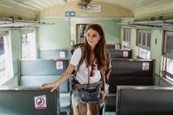 Woman in White Shirt and Blue Denim Shorts Standing Beside Black and Gray Metal Cabinet
