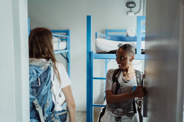 Backpackers with rucksacks in a hostel dormitory &mdash; Travel Destinations by Budget