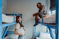 Woman in White Shirt Sitting on Blue Bed