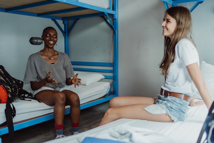 Women Sitting On Bunk Bed And Smiling 