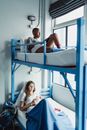 Woman in Blue Tank Top Lying on Bed Beside Woman in White Shirt
